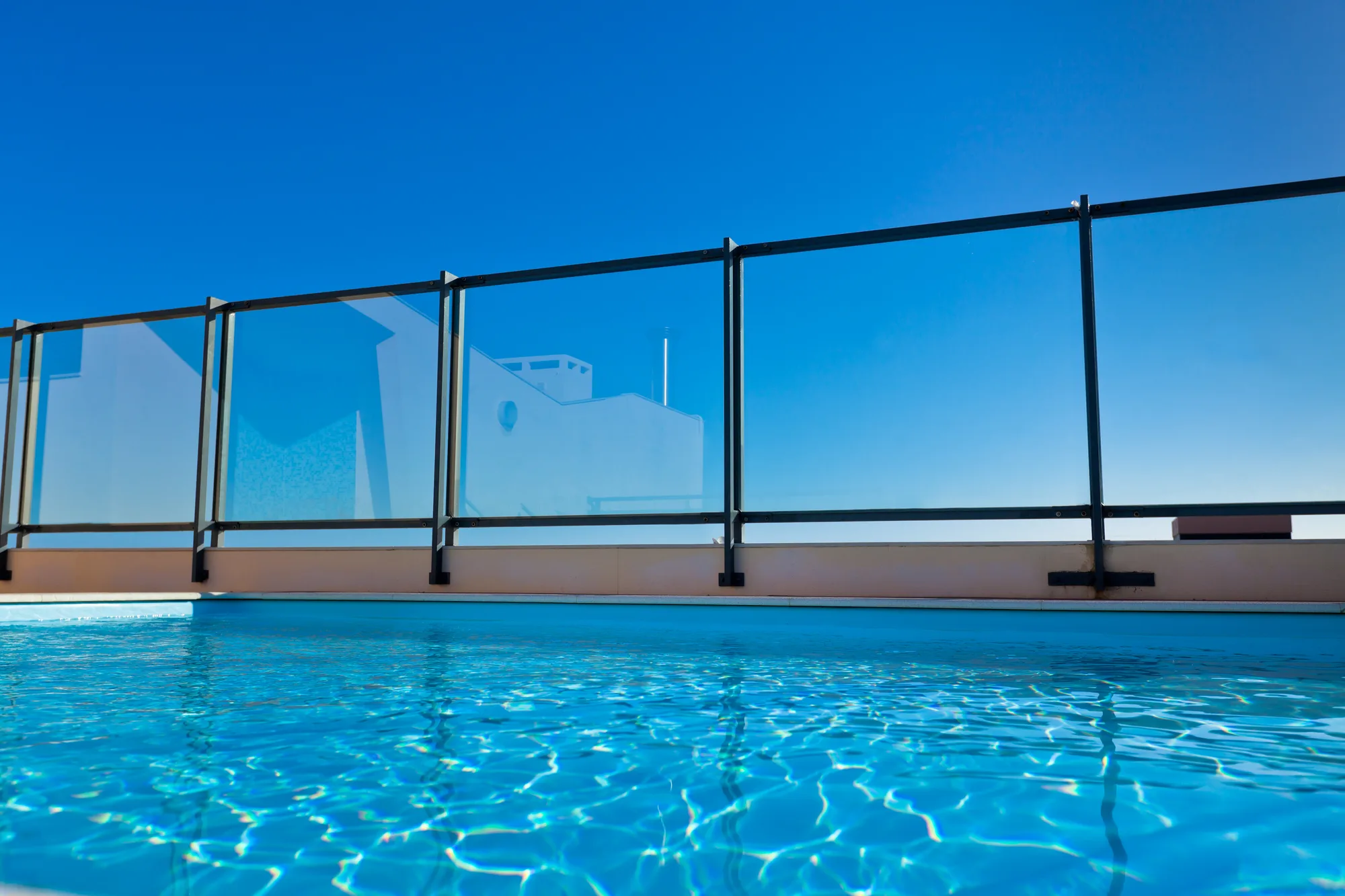 A frameless glass balustrade on a high-rise rooftop pool area