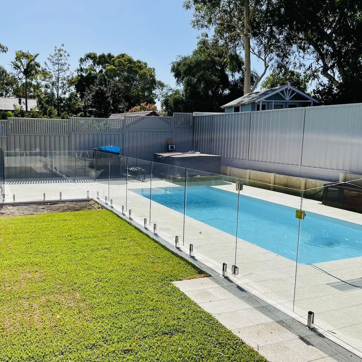 A frameless glass pool fence around a newly finished Brisbane pool